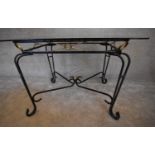 A wrought iron conservatory table with bevelled glass top. H.73 x 115cm