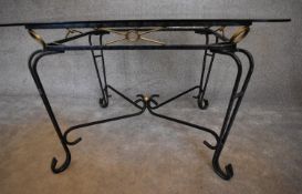 A wrought iron conservatory table with bevelled glass top. H.73 x 115cm