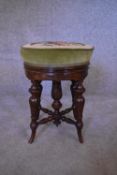 A Victorian walnut piano stool with adjustable tapestry upholstered seat. H.48 x 38cm