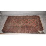 A Bokhara style rug with elephant pad motifs on a terracotta field encompassed with mutli