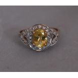 A modern Lemon apatite and zircon cluster ring. Set to centre with an oval mixed cut Lemon Apatite