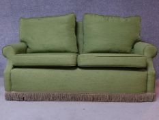 A contemporary green fabric two seater sofa, on casters. H.82 W.165 D.85cm