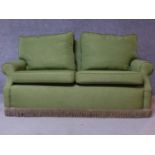 A contemporary green fabric two seater sofa, on casters. H.82 W.165 D.85cm