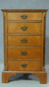 A Georgian style burr walnut bedside cabinet fitted with five short drawers, raised on bracket feet.