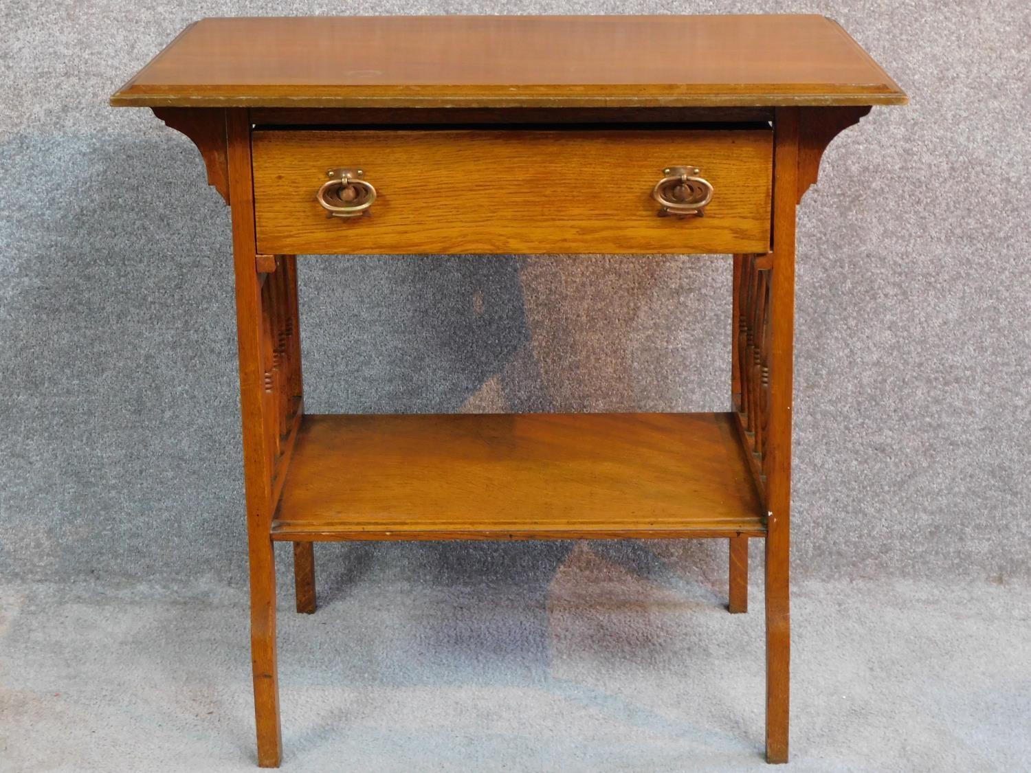 An Arts and Crafts oak hall table with frieze drawer and under tier, raised on square supports. H.75
