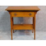 An Arts and Crafts oak hall table with frieze drawer and under tier, raised on square supports. H.75