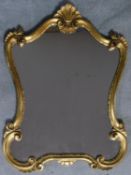 A gilt rococo style shell carved mirror. 92x65cm