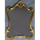 A gilt rococo style shell carved mirror. 92x65cm