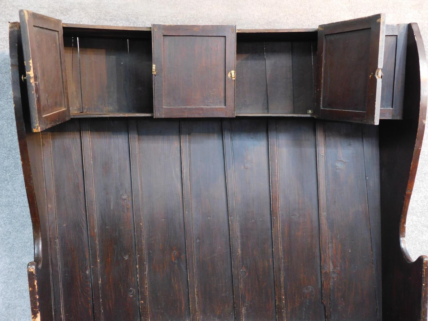 A large Georgian oak hall bench of curved outline fitted cupbooards to the upper section. W.146 D. - Image 2 of 4