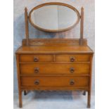 An antique style oak dressing table with two short over two long drawers, mounted oval mirror and