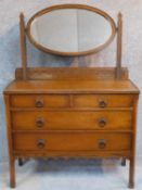 An antique style oak dressing table with two short over two long drawers, mounted oval mirror and