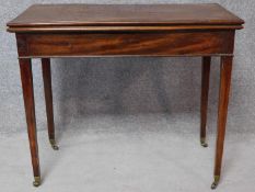 An Georgian mahogany foldover top card table raised on square tapering supports terminating in
