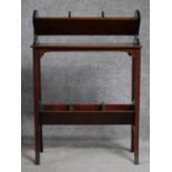 A late Victorian mahogany book trough with under tier, raised on square stretchered swept