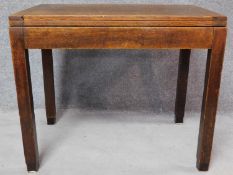 A mid 20th century oak fold over top table with interior compartment, raised on square supports. H.
