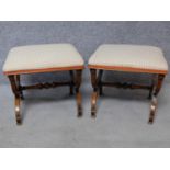 A pair of early Victorian mahogany footstools with stuffover upholstered seats on stretchered x