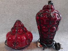 A pair of 1920's blown red glass lights, one table lamp with wirework design and one similar