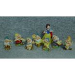 A collection of porcelain hand painted figures of Snow White and the seven dwarves by Schmid for The