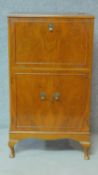 A Georgian style figured walnut cocktail cabinet fitted with mirrored interior raised on cabriole