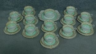 A hand painted Paragon part tea set comprising of 12 cups and saucers, a plate and bowl. Painted