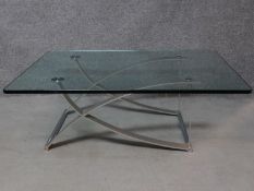 A contemporary glass coffee table raised on chrome supports, by Rolf Benz. H.42 W.120 D.90cm