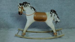 A vintage fabric covered rocking horse with brown leather saddle, wooden muzzle and fabric mane. H.