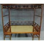 A Chinese hardwood four poster bedframe with woven base and pierced fretwork canopy. H.201 W.280 D.