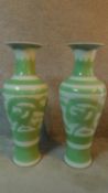 A pair of modern Kangxi style pale green and white glazed ceramic dragon vases. Signature to base.