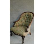 A Victorian mahogany framed floral upholstered buttoned back armchair raised on carved cabriole