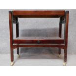 A mid 20th century mahogany metamorphic tea trolley raised on stretchered square supports with