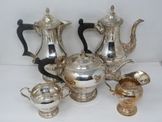 A five piece matching silver tea service. Includes a water jug, coffee pot, tea pot, sugar bowl