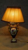 A porcelain hand painted converted vase to lamp with floral design and swan gilt painted handles, by