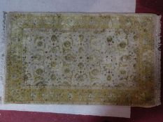 A Persian rug, all over spandrel motifs with repeating petal motifs on a ivory and yellow field,