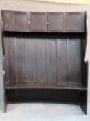 A large Georgian oak hall bench of curved outline fitted cupbooards to the upper section. W.146 D.