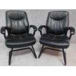 Two contemporary leather office armchairs, raised on metal supports. H.98cm
