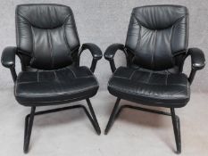 Two contemporary leather office armchairs, raised on metal supports. H.98cm