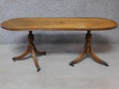 A Georgian style flame mahogany and crossbanded coffee table raised on a pair of reeded tripod