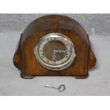 An antique walnut clock with white enamel face and black Roman numerals, stamped made in England