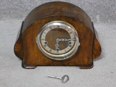 An antique walnut clock with white enamel face and black Roman numerals, stamped made in England