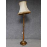 A Victorian style birch tall lamp with floral carved gilt details and lion feet. H.180cm