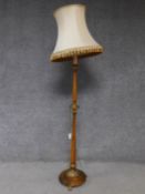 A Victorian style birch tall lamp with floral carved gilt details and lion feet. H.180cm