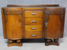 A mid-20th century Art Deco style oak carved sideboard with fitted drinks compartment to door