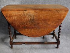 A mid 20th century oak drop flap dining table on on barleytwist supports. H.72 W.132 D.105cm