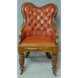 A William IV mahogany framed buttoned back library chair in tan leather upholstery on facetted
