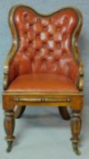 A William IV mahogany framed buttoned back library chair in tan leather upholstery on facetted