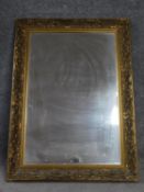 A framed giltwood floral carved bevelled wall mirror. 109x78cm