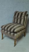 A 19th century style nursing chair in striped upholstery on turned tapering supports. H.87cm