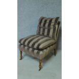 A 19th century style nursing chair in striped upholstery on turned tapering supports. H.87cm