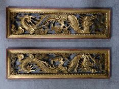 A pair of antique Chinese carved giltwood and red lacquer panels with dragon and cloud decoration.