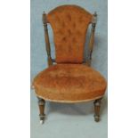 A late 19th century walnut framed buttoned back nursing chair on turned tapering supports. H.82cm