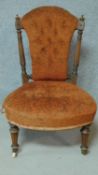 A late 19th century walnut framed buttoned back nursing chair on turned tapering supports. H.82cm